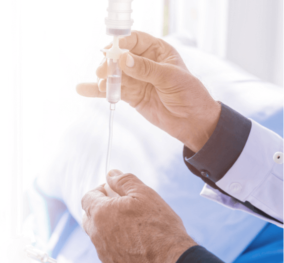 medical professional's hands adjusting an IV drip